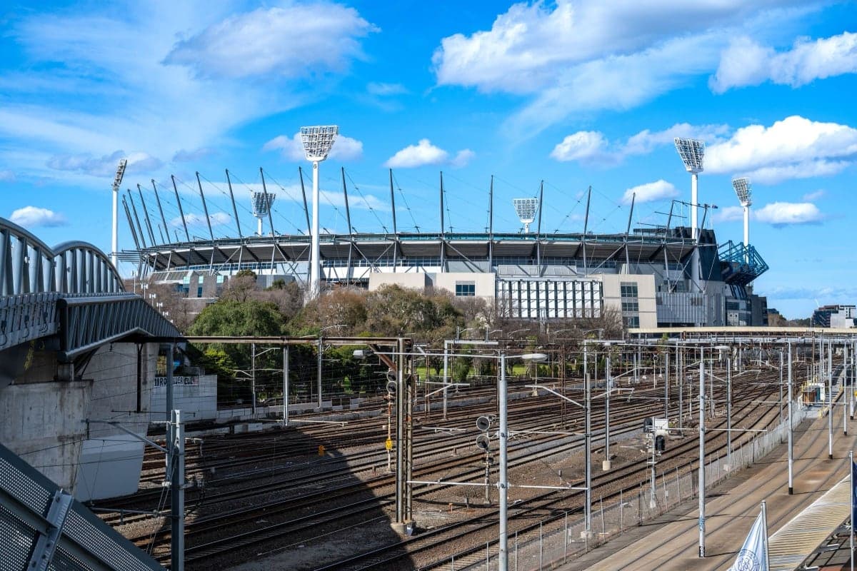 The Melbourne Cricket Ground and the Richmond railway lines on a sunny day, with Melbourne Park beyond