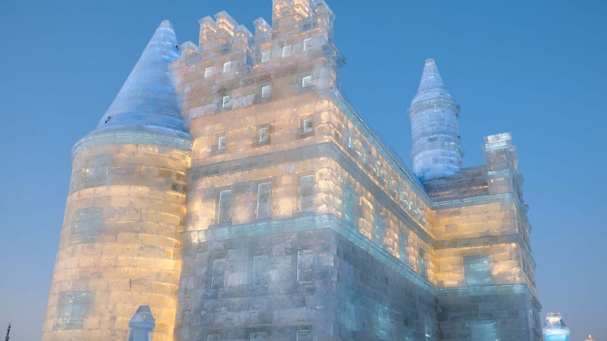Illuminated ice castle at Harbin Ice-Snow World at dusk