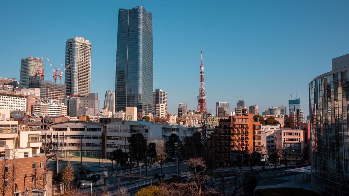 Tokyo Tower and high-rise towers in Minato, Tokyo, under a clear blue sky