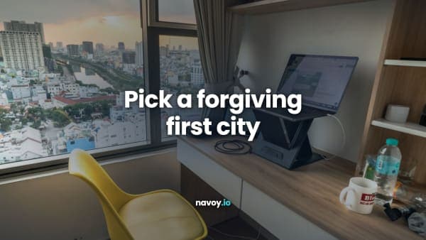 Desk with a laptop and yellow chair by a window over a city
